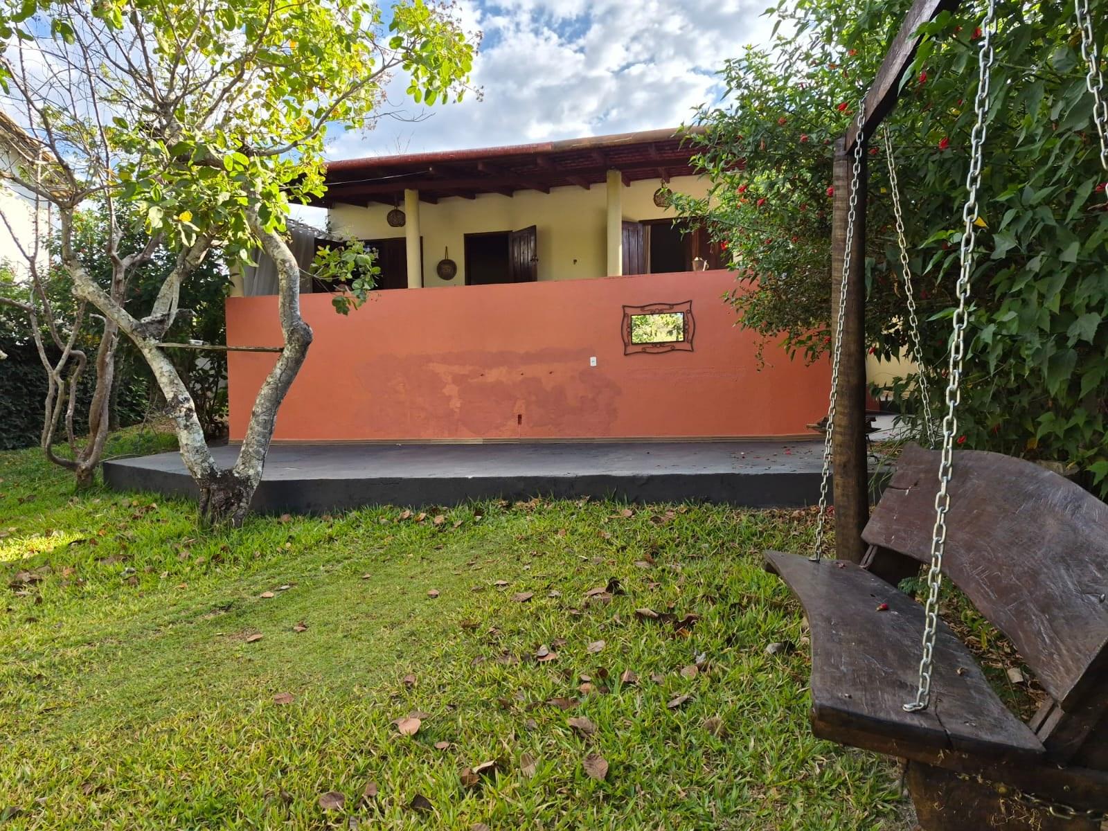 Pátio dos fundos da casa, com balanço de madeira e gramado