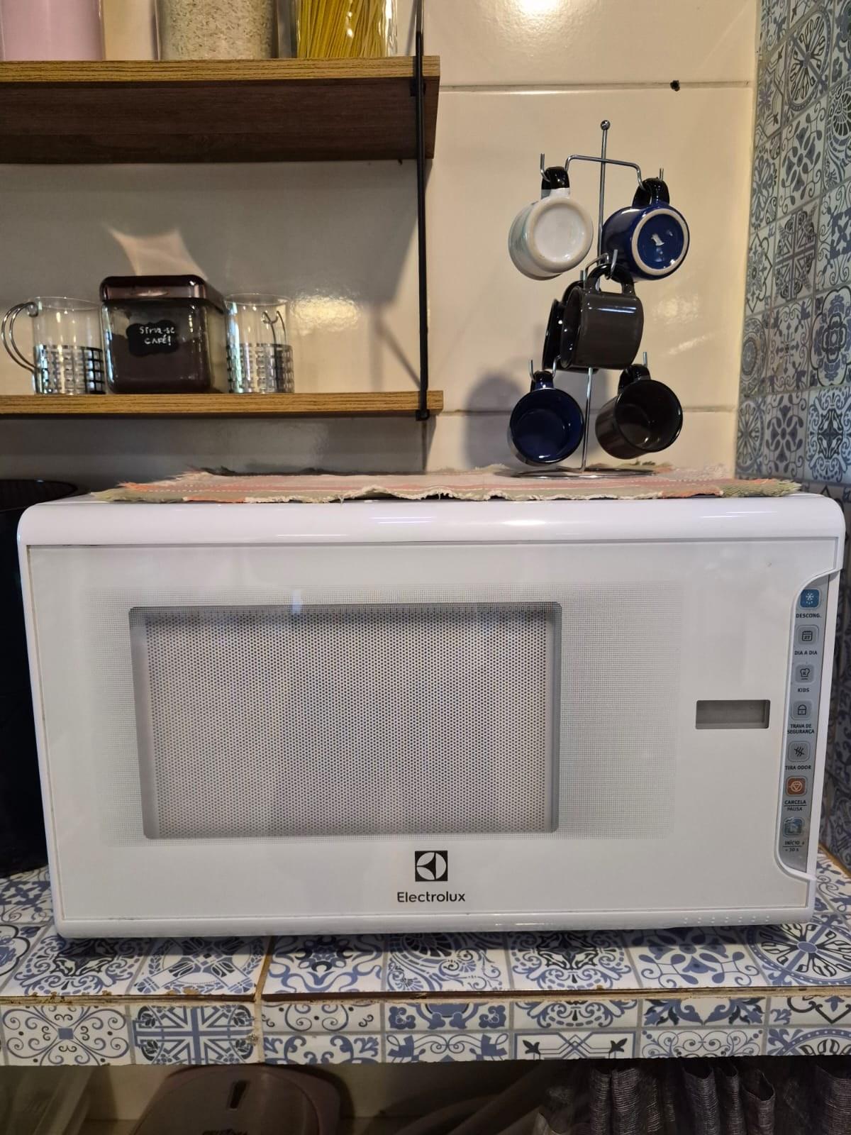 Micro-ondas e xícaras na cozinha