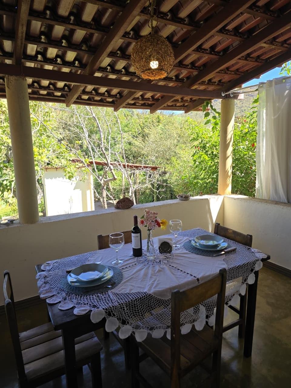 Mesa posta na varanda, com taças e flores