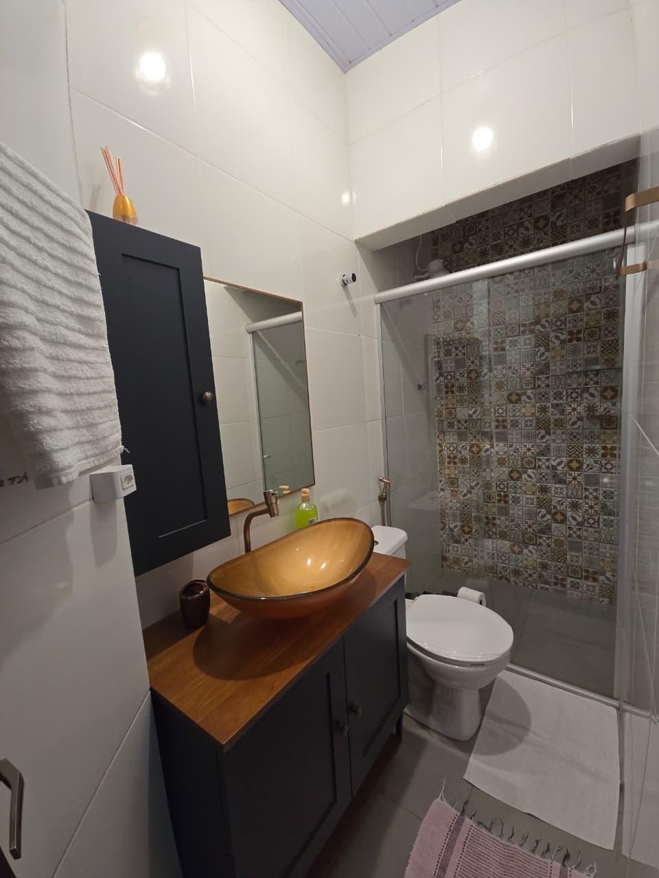 Banheiro com box de vidro e azulejo estampado