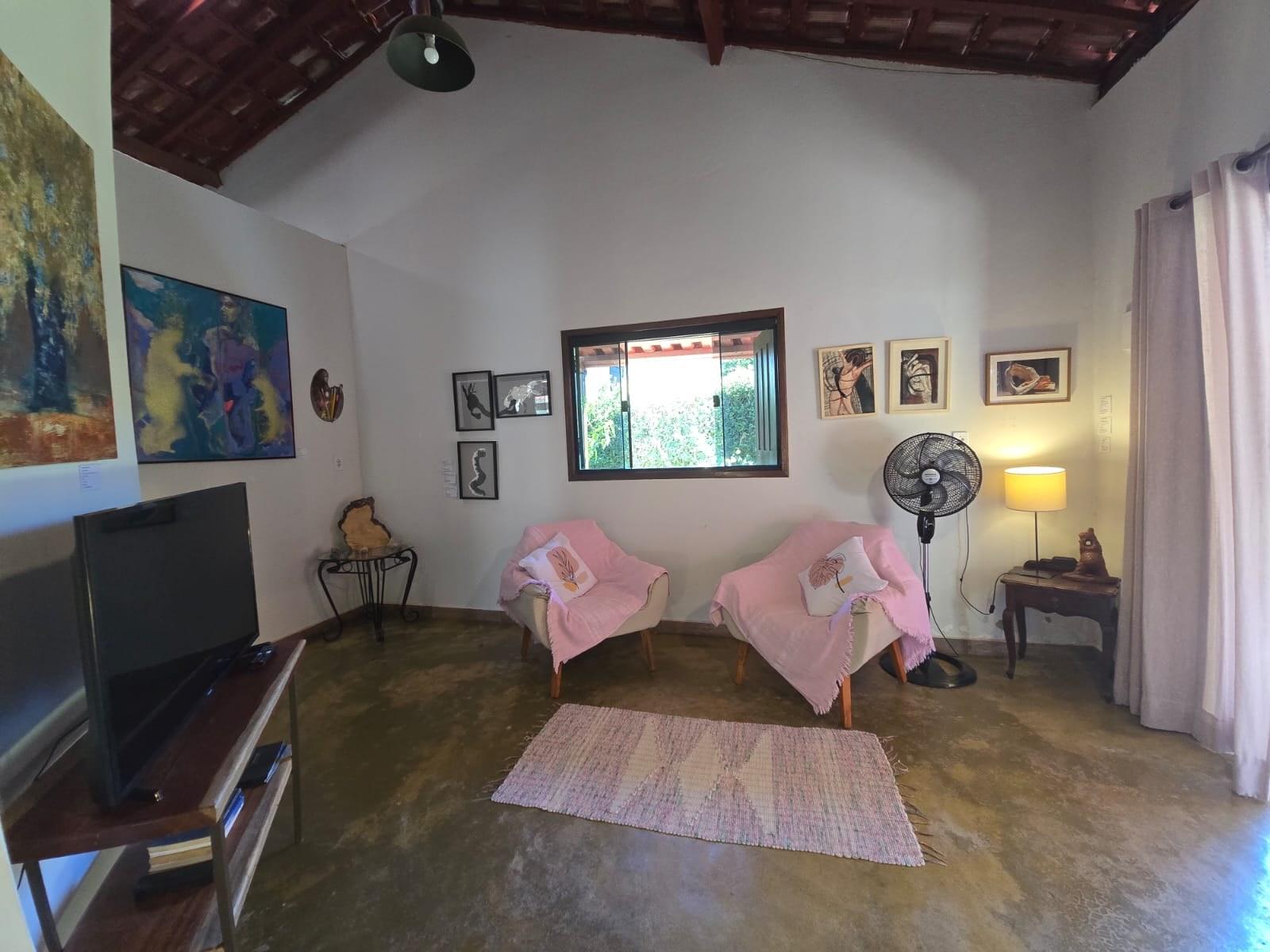 Sala de estar com TV e obras de arte nas paredes